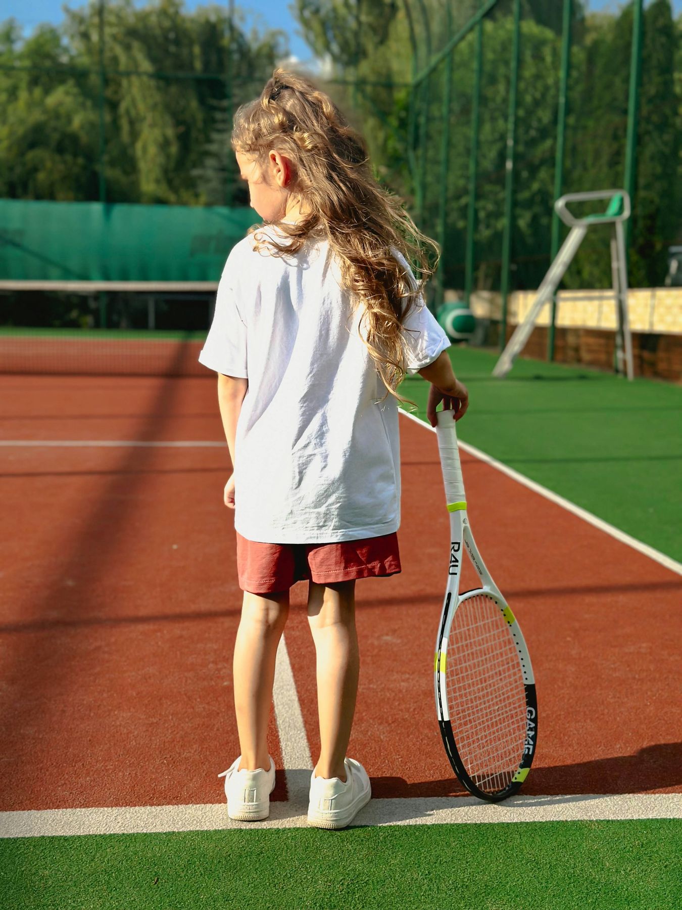 A young player holding a racquet on the court